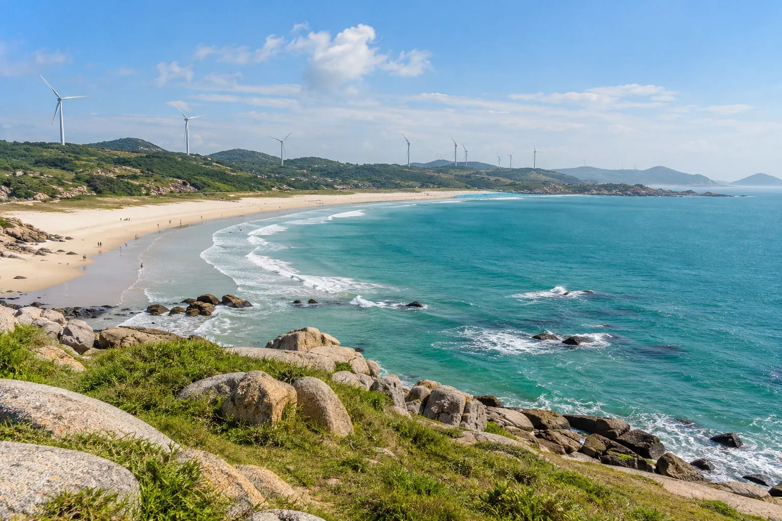 A sandy bay, granite shoreline and wind turbines on the Pingtan coast