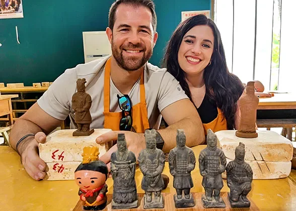 Travellers with small terracotta figures in a workshop